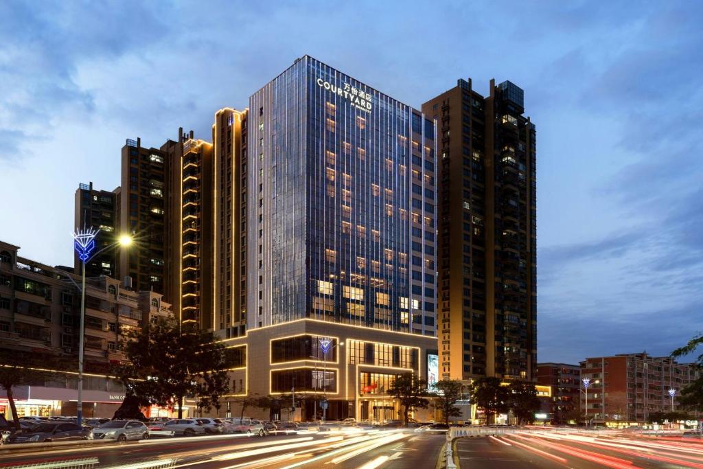 a tall building in a city at night at Courtyard by Marriott Shanwei Haifeng in Shanwei