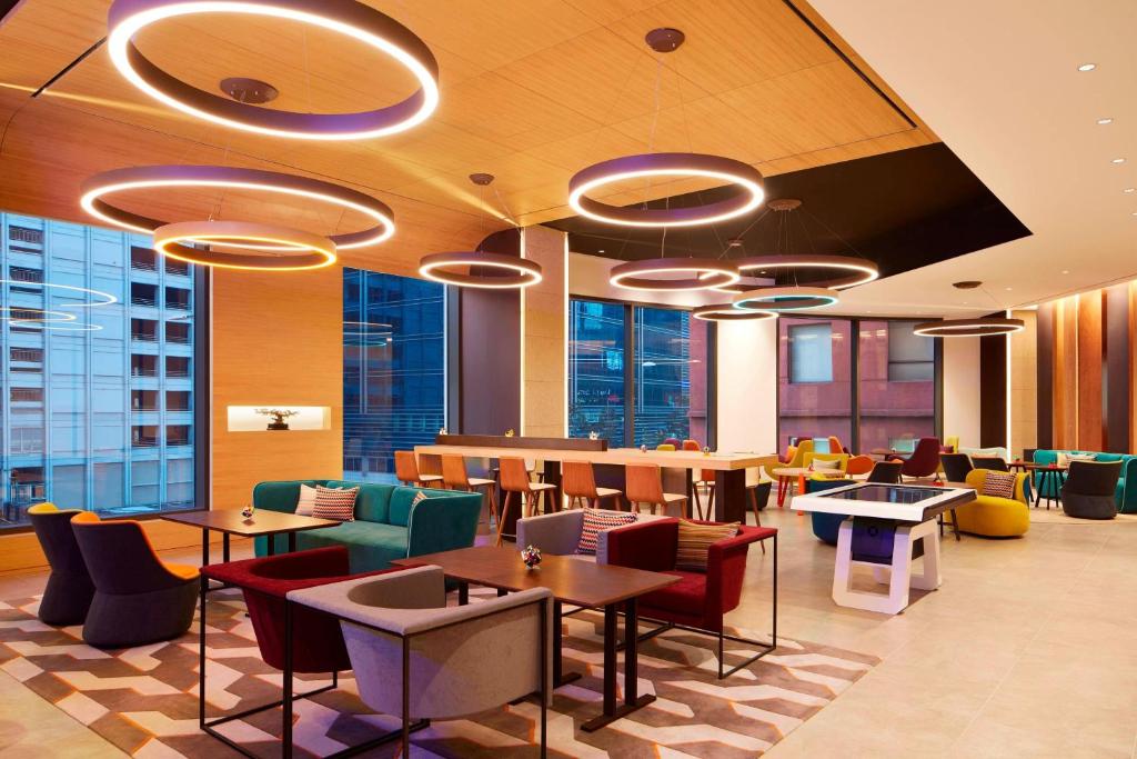 a restaurant with tables and chairs and windows at Aloft Seoul Myeongdong in Seoul