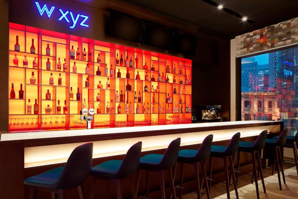 a bar with chairs and a display of wine bottles at Aloft Seoul Myeongdong in Seoul