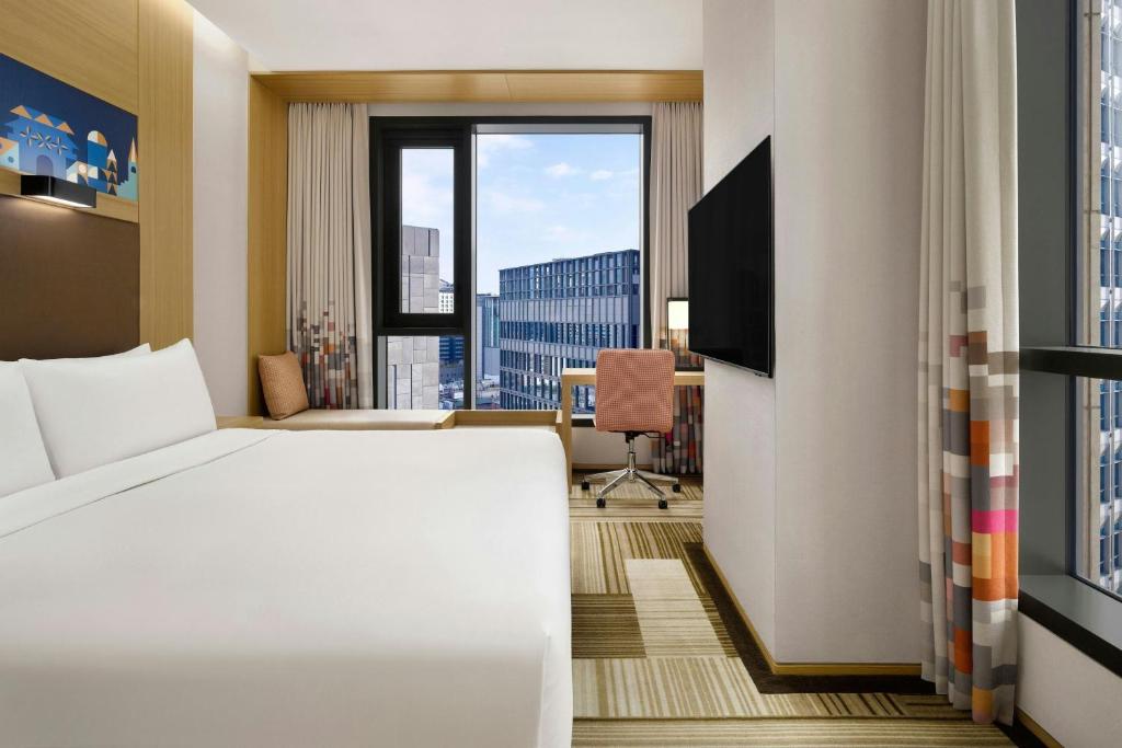 a hotel room with a bed and a large window at Aloft Seoul Myeongdong in Seoul