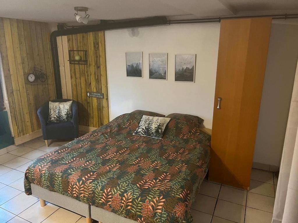 une chambre avec un lit et une chaise dans l'établissement Studio le petit Bouclet, au Tréport