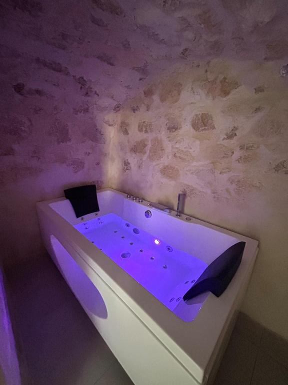 - une baignoire avec éclairage violet dans la chambre dans l'établissement Le provencal, à La Roque-dʼAnthéron