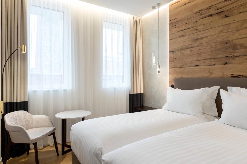 a bedroom with a white bed and a chair at AC Hotel Venezia by Marriott in Venice