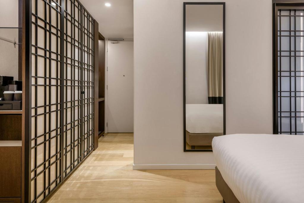 a bedroom with a bed and a mirror at AC Hotel Venezia by Marriott in Venice