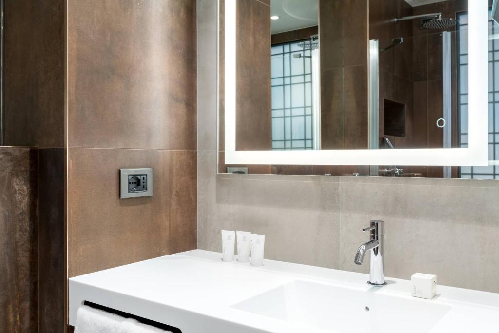 a bathroom with two sinks and a mirror at AC Hotel Venezia by Marriott in Venice