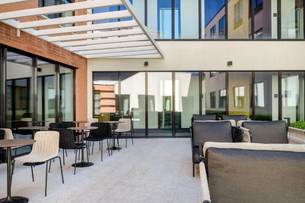 a restaurant with tables and chairs and windows at AC Hotel Venezia by Marriott in Venice