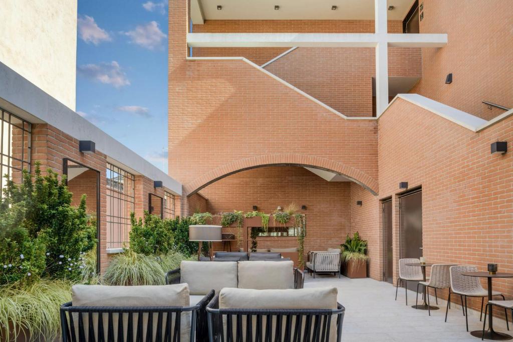 a patio with chairs and tables in front of a brick building at AC Hotel Venezia by Marriott in Venice