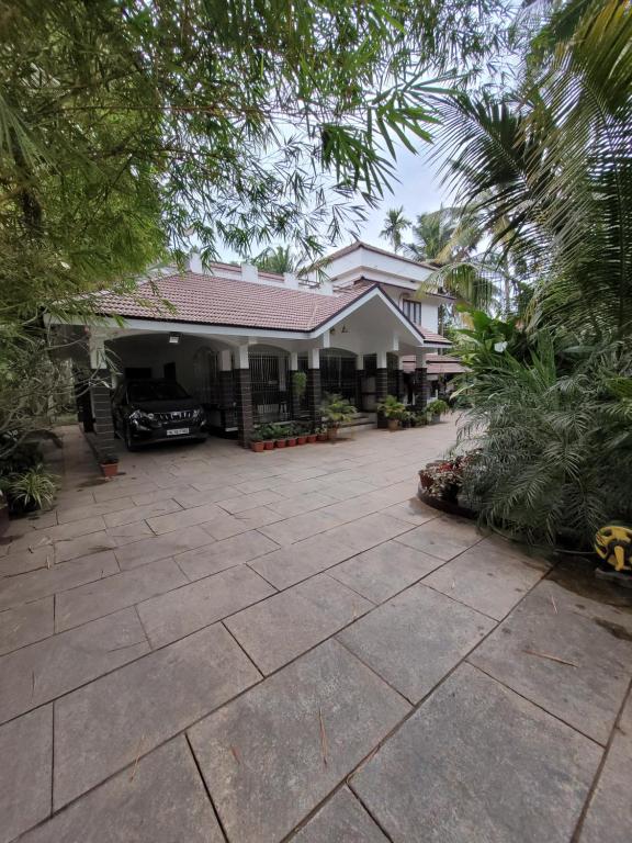 a house with a driveway in front of it at Akalapuzha Homestay in Kozhikode