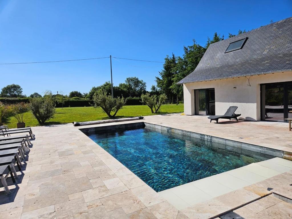 une piscine dans l'arrière-cour d'une maison dans l'établissement La Parenthèse Normande, à Saint-Cyr-du-Ronceray