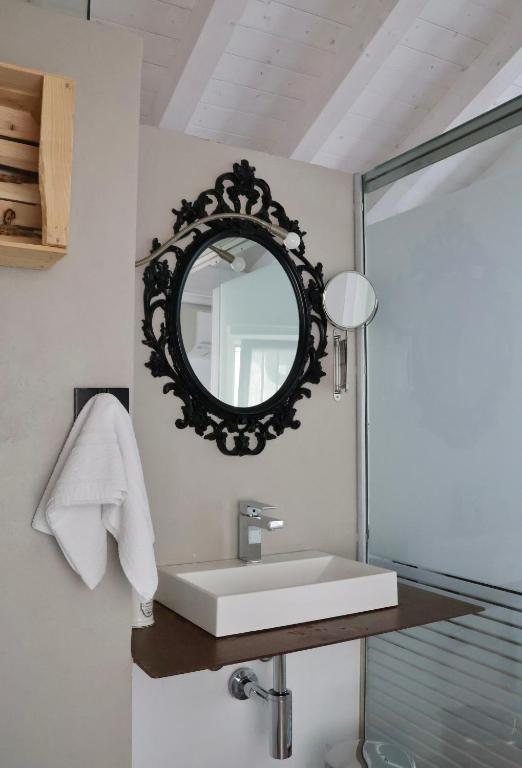 łazienka z umywalką i lustrem w obiekcie Bed and Breakfast Casa del Nonno w mieście Adrara San Rocco
