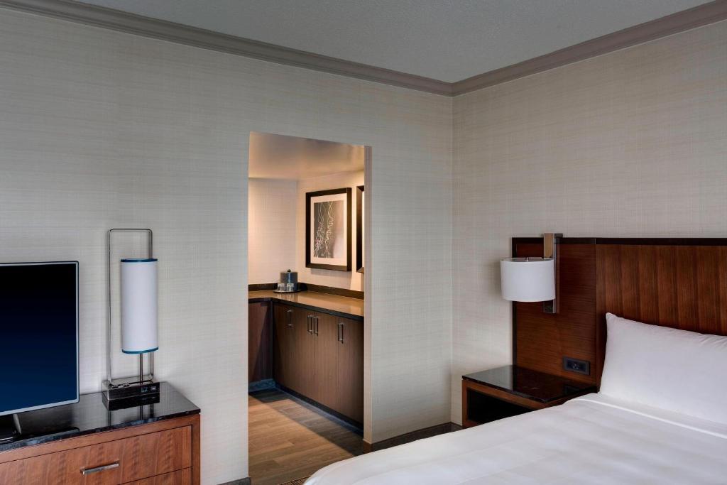 a hotel room with a bed and a television at Houston Airport Marriott at George Bush Intercontinental in Houston