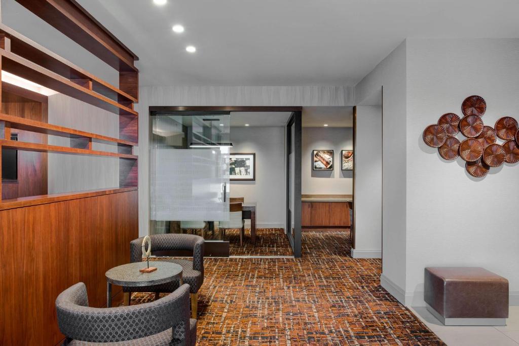 a lobby with chairs and a table and a table at Houston Airport Marriott at George Bush Intercontinental in Houston