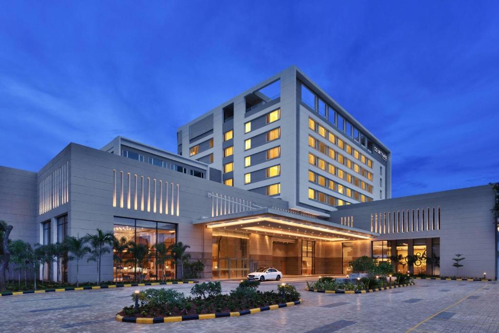 un edificio con un coche aparcado delante en Courtyard by Marriott Madurai, en Madurai
