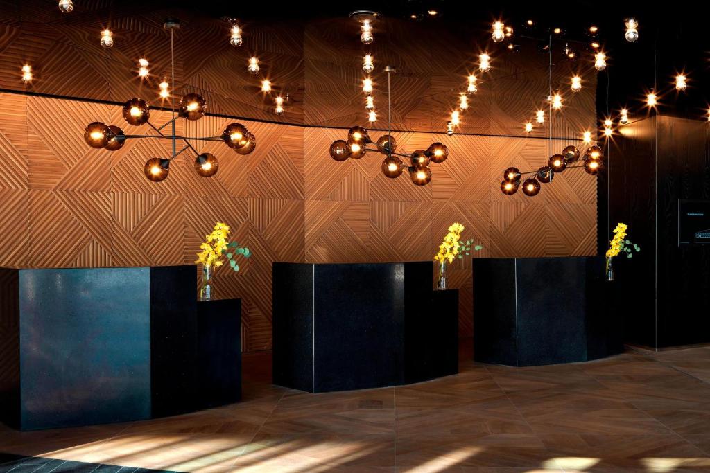a room with two tables with plants and lights at Renaissance Warsaw Airport Hotel in Warsaw