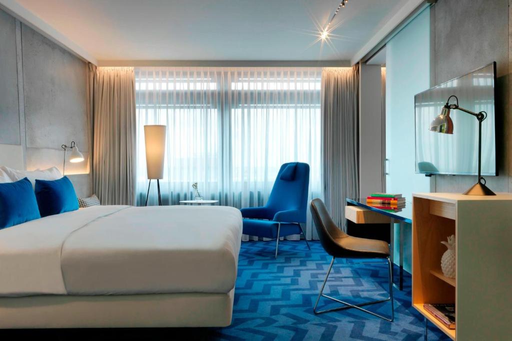 a hotel room with a large bed and a desk at Renaissance Warsaw Airport Hotel in Warsaw