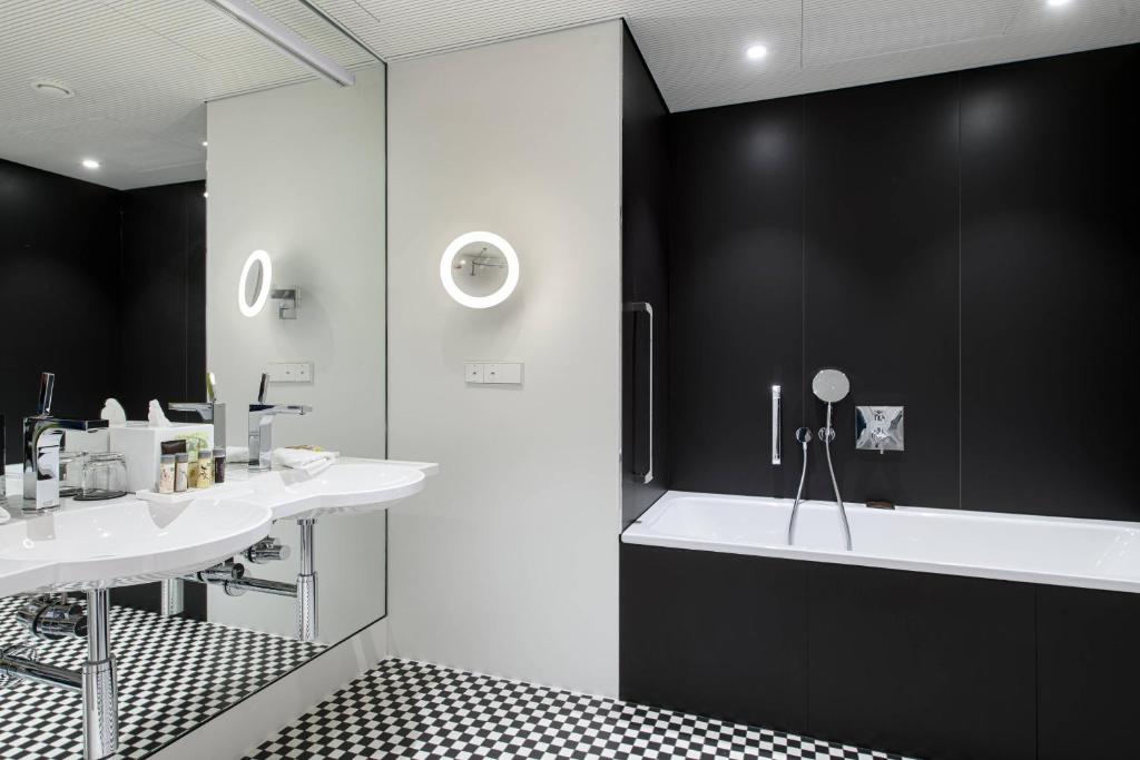 a bathroom with a white tub and a sink at Renaissance Warsaw Airport Hotel in Warsaw