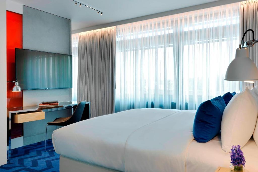 a hotel room with a large bed and a desk at Renaissance Warsaw Airport Hotel in Warsaw