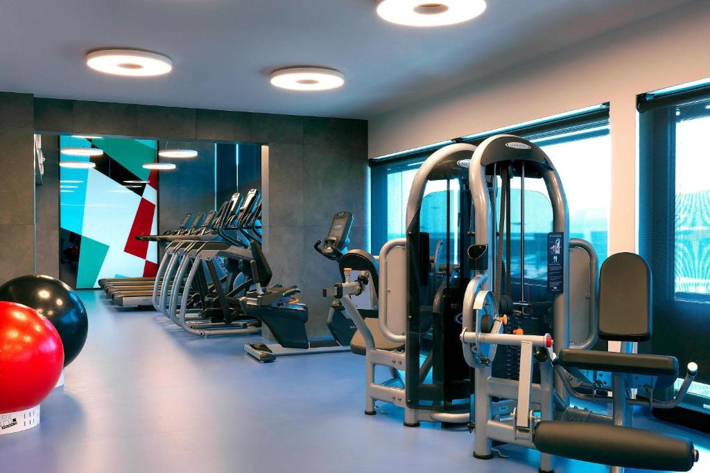 a gym with rows of treadmills and exercise bikes at Renaissance Warsaw Airport Hotel in Warsaw