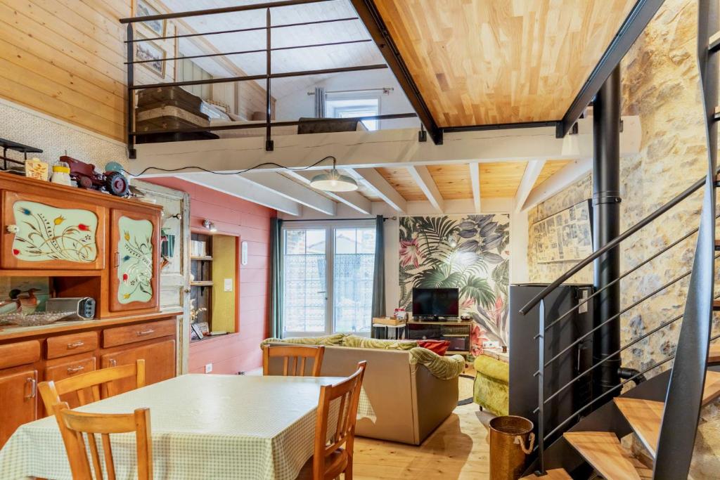 une cuisine avec une table et une salle à manger dans l'établissement Charmant gîte à la campagne, proche du Puy du Fou, Les Charmes de Castellariis, à Pouzauges