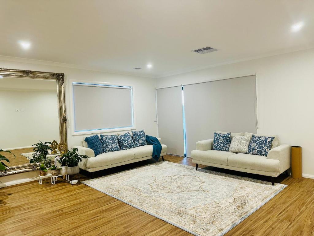 a living room with two couches and a mirror at Cozy Homez Ballarat - Home stay in Alfredton