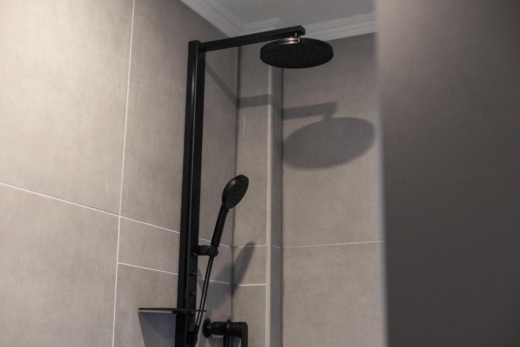 a shower with a shower head in a bathroom at Mokka Suite Design in Neumünster in Neumünster