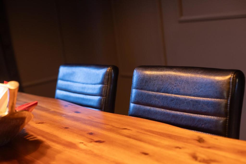 a wooden table with two blue chairs in a room at Mokka Suite Design in Neumünster in Neumünster