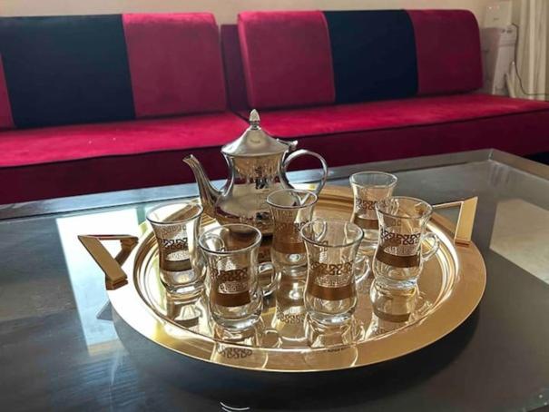 a tray with a tea kettle and glasses on a table at عمارة المحيسني in Makkah