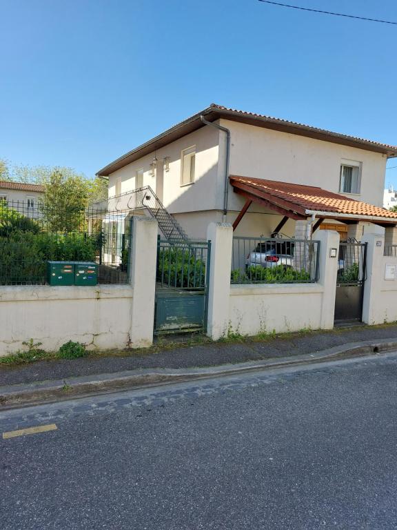 une maison blanche avec un portail et une clôture dans l'établissement Jardin Dangla 