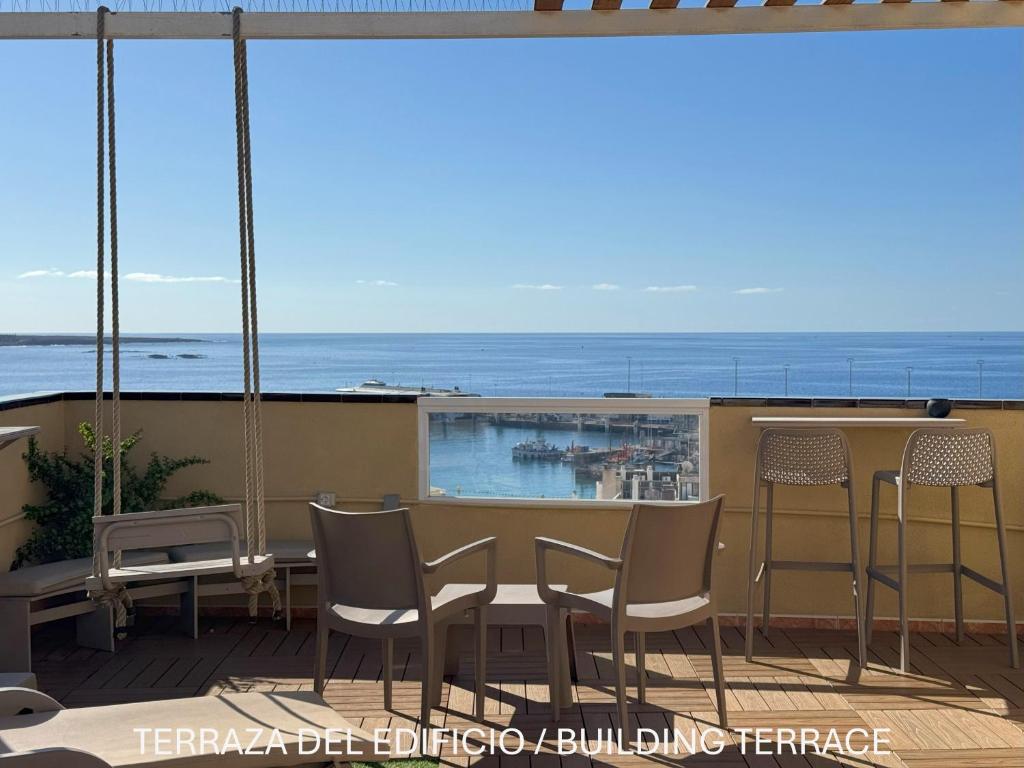 a balcony with a table and chairs and the ocean at Apartamentos Ohana - Edificio Tonillo in Los Cristianos