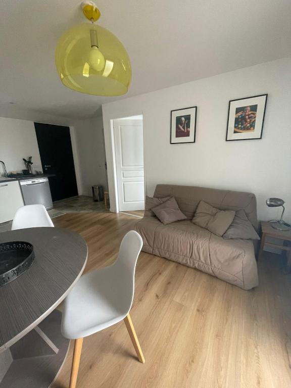 a living room with a couch and a table at T2 au calme, la mer à proximité in Villeneuve-lès-Maguelonne