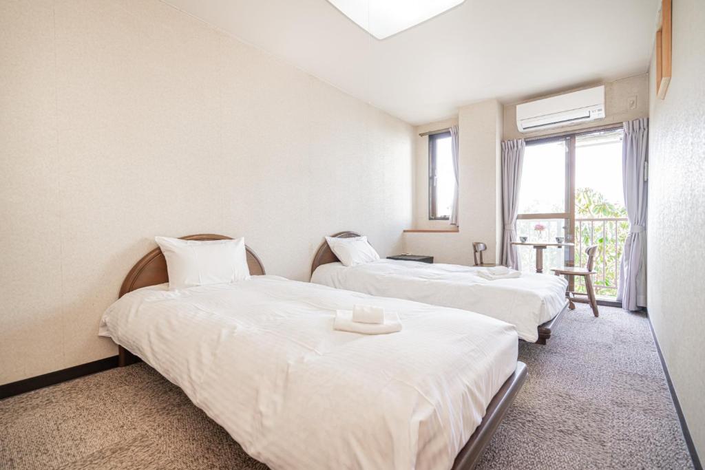 御殿場市にあるFujiminoyado - Vacation STAY 62143vの窓のある部屋にベッドが2つある