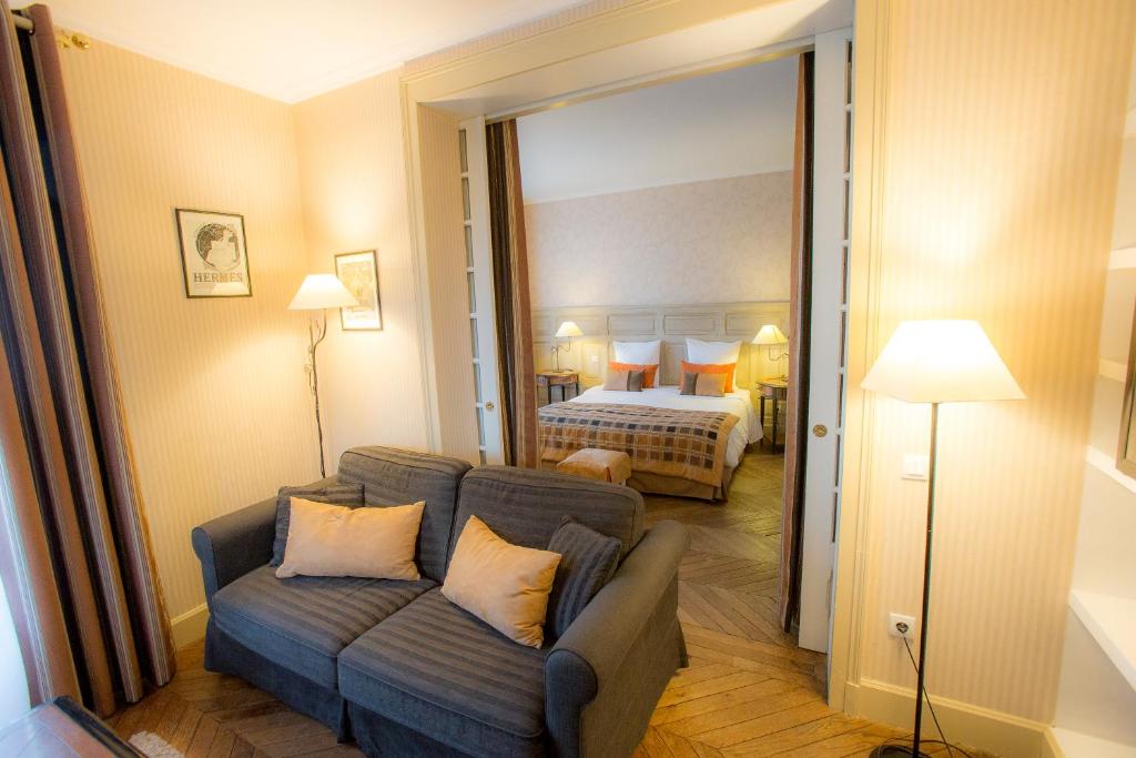 a living room with a couch and a bedroom at Villa Augeval Hôtel de charme & Spa in Deauville