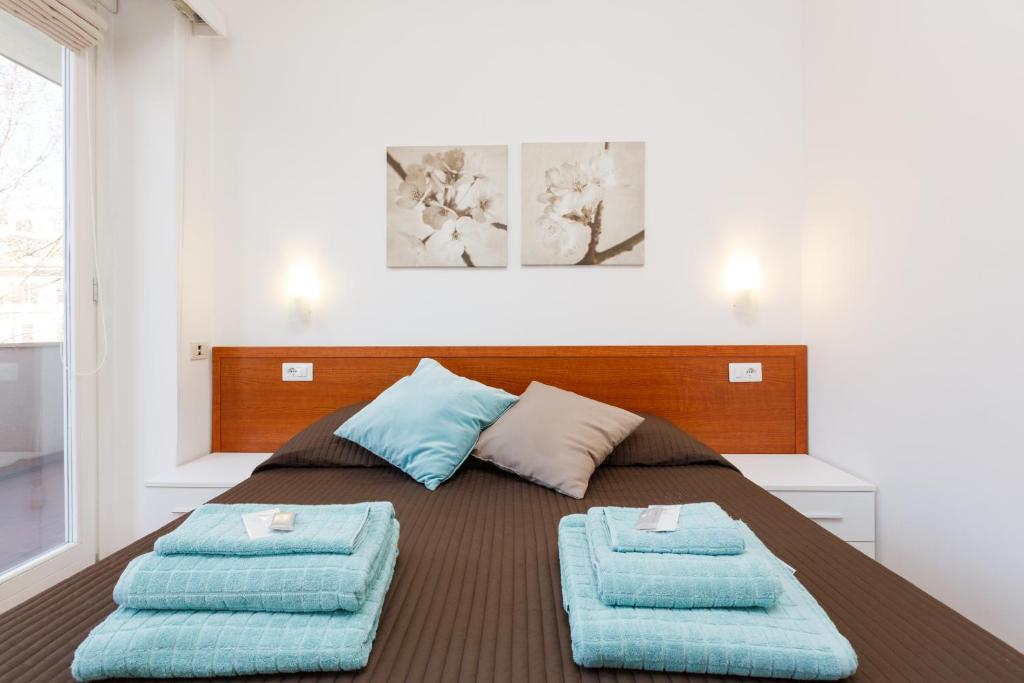 a bedroom with a bed with blue pillows on it at Roma Trastevere Relais Guest House in Rome