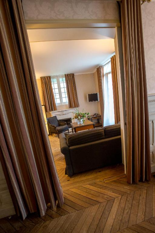 a living room with a couch and a table at Villa Augeval Hôtel de charme & Spa in Deauville