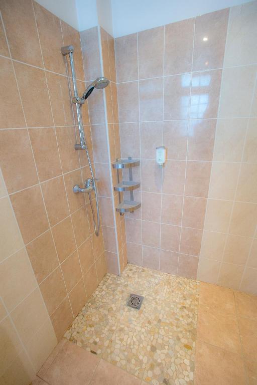 a bathroom with a shower with a glass door at Villa Augeval Hôtel de charme & Spa in Deauville