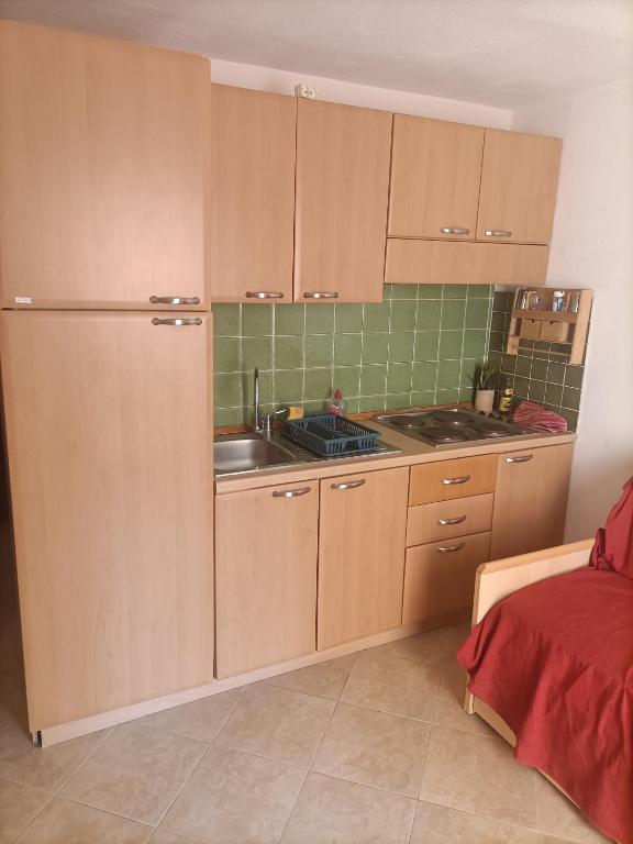 une cuisine avec des armoires en bois et un évier dans l'établissement Les jardins de la mer marine de Bravone, à Linguizzetta