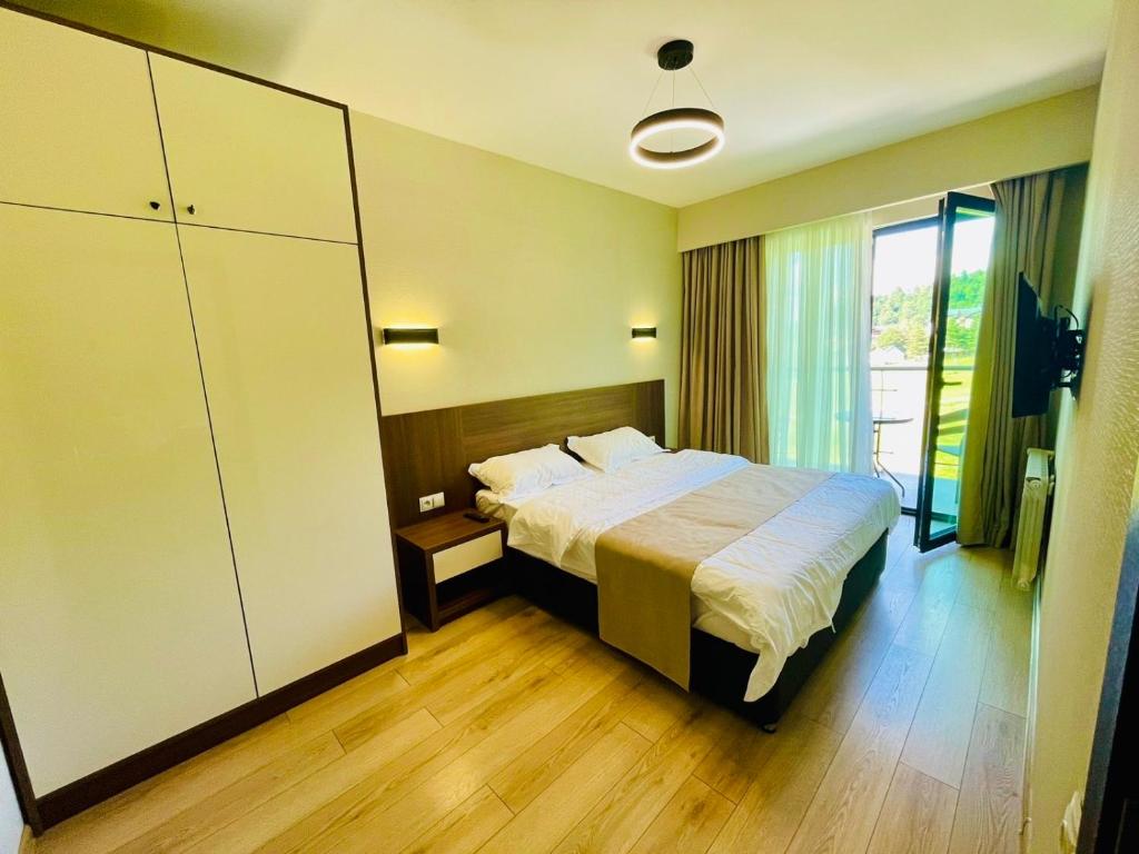 a hotel room with a bed and a large window at Bakuriani, crystal residence 405 room in Bakuriani