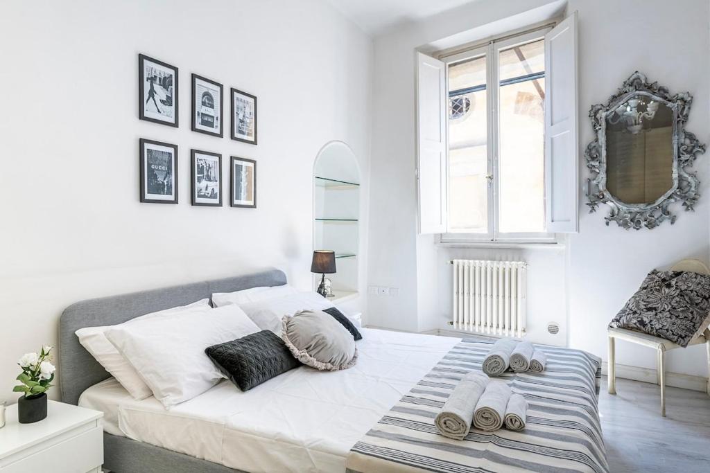 a white bedroom with a bed with slippers on it at Old Town, near Ponte Vecchio in Florence