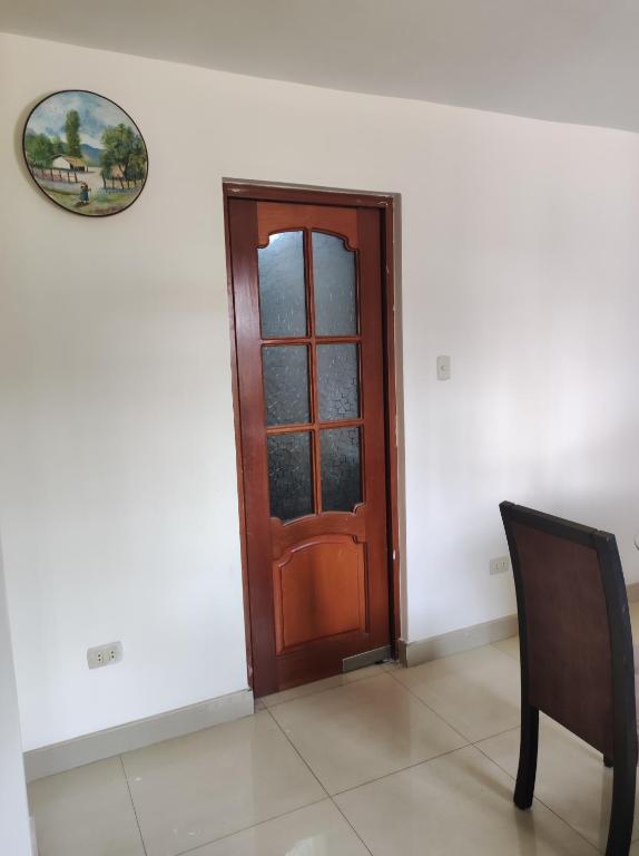 a wooden door in a white room with a chair at no disponibl in Trujillo