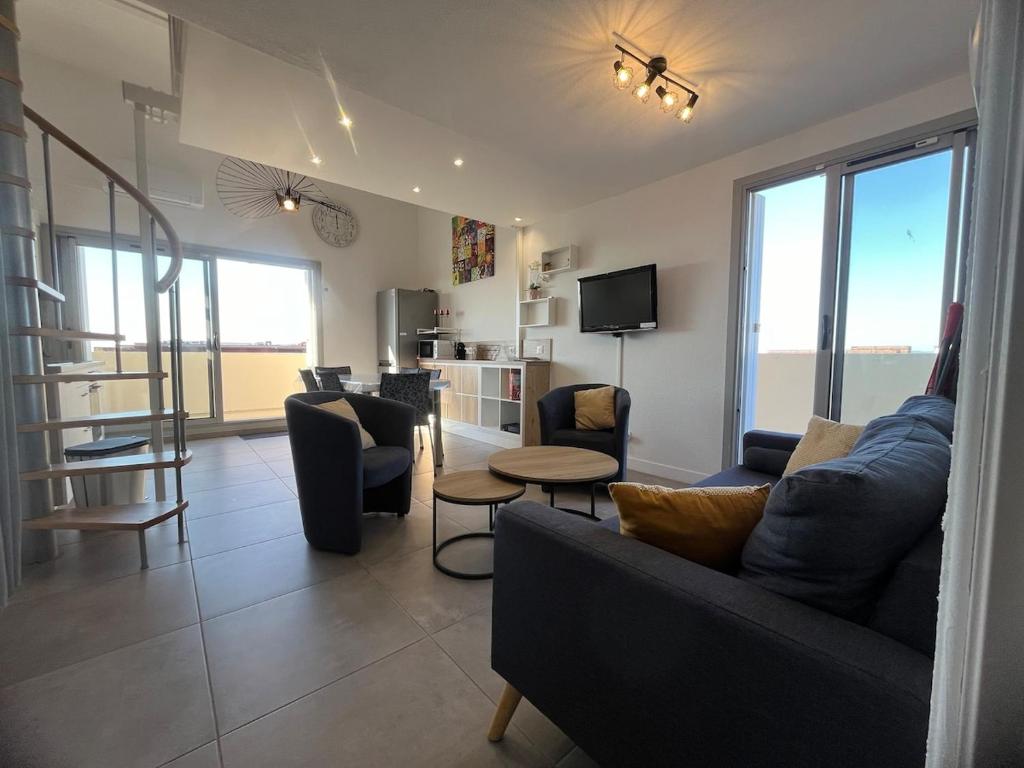 un salon avec un canapé, des chaises et une table dans l'établissement La Goelette T3 rayonnant parking 6 pers max, à Sète