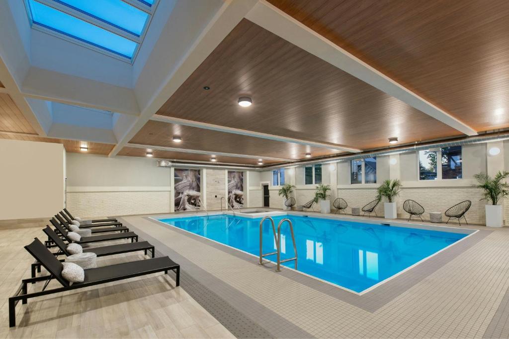a large swimming pool in a building with a swimming pool at The Insignia Hotel, Sarnia, a Tribute Portfolio Hotel in Sarnia