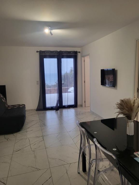 - un salon vide avec une table et des chaises dans l'établissement Solenzara T2 proximité plage, à Sari-Solenzara