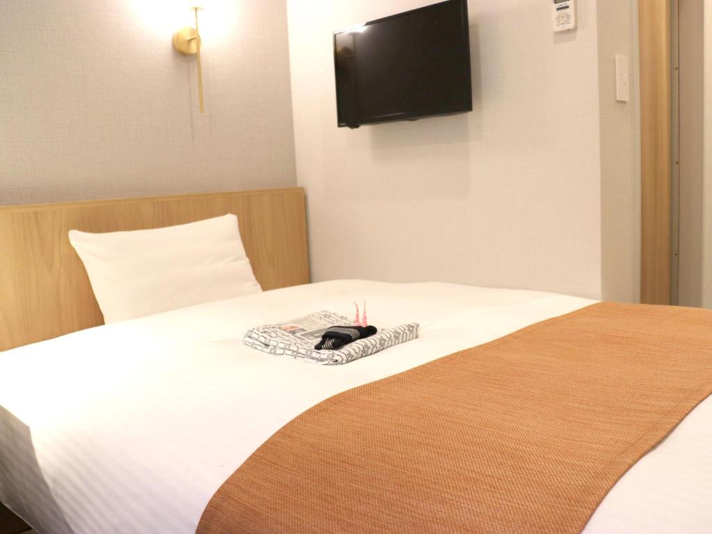 東京にある東京インのホテルルーム ベッド1台(帽子付)