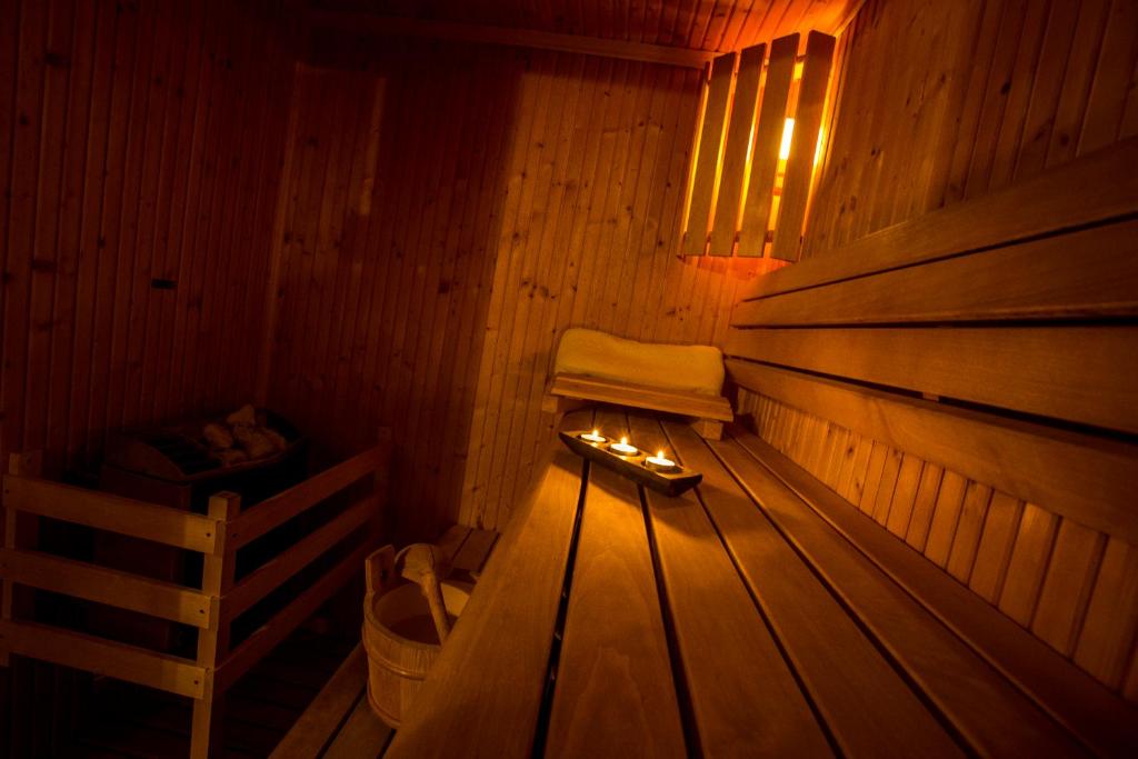 a wooden sauna with a bench and a fire in it at Villa Augeval Hôtel de charme & Spa in Deauville