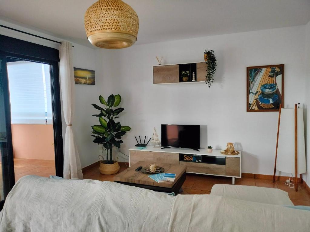 a living room with a couch and a tv at La casita de Taty in Majanicho