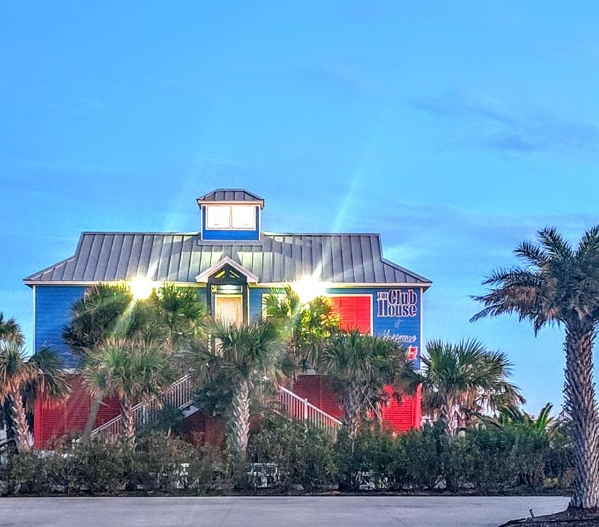 a building with a tower on top of it with palm trees at Sea la vie in Grand Isle