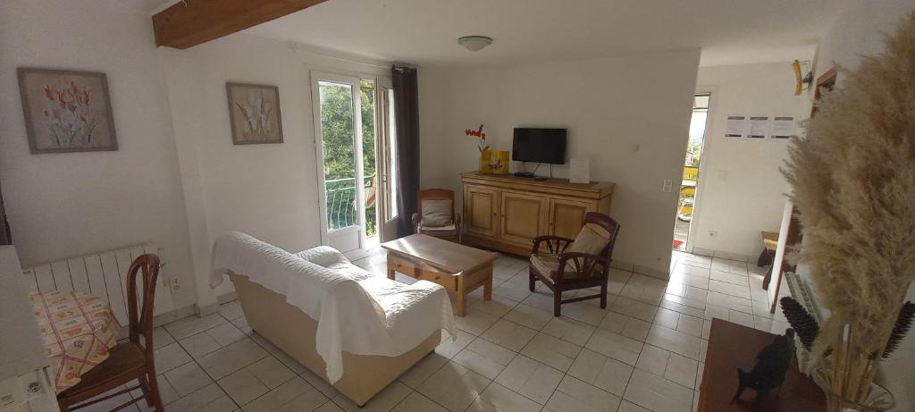 un salon avec un canapé, des chaises et une télévision dans l'établissement Residence PLEIN SUD, à Péré