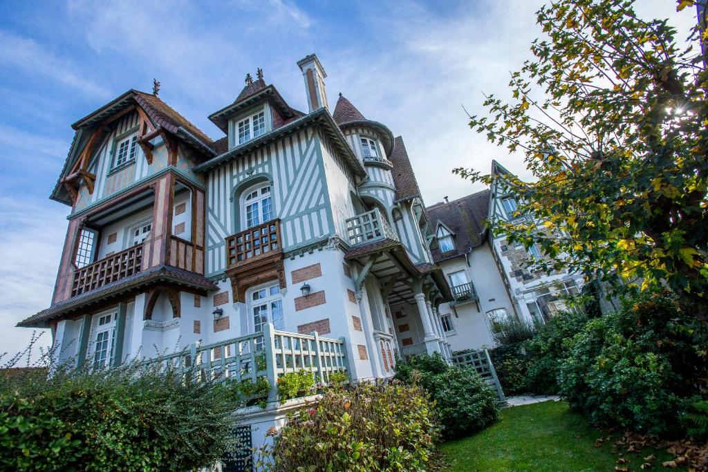 a large white house with a lot of windows at Villa Augeval Hôtel de charme & Spa in Deauville