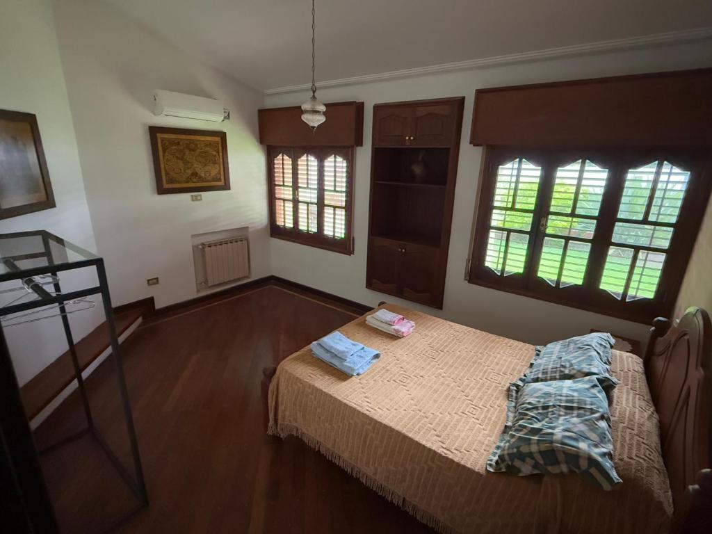 une chambre avec un lit et deux fenêtres dans l'établissement Departamento Temporal, à San Fernando del Valle de Catamarca