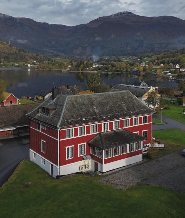 an aerial view of a large red building with a lake at Huset Vårt - Bed and Breakfast in Hornindal